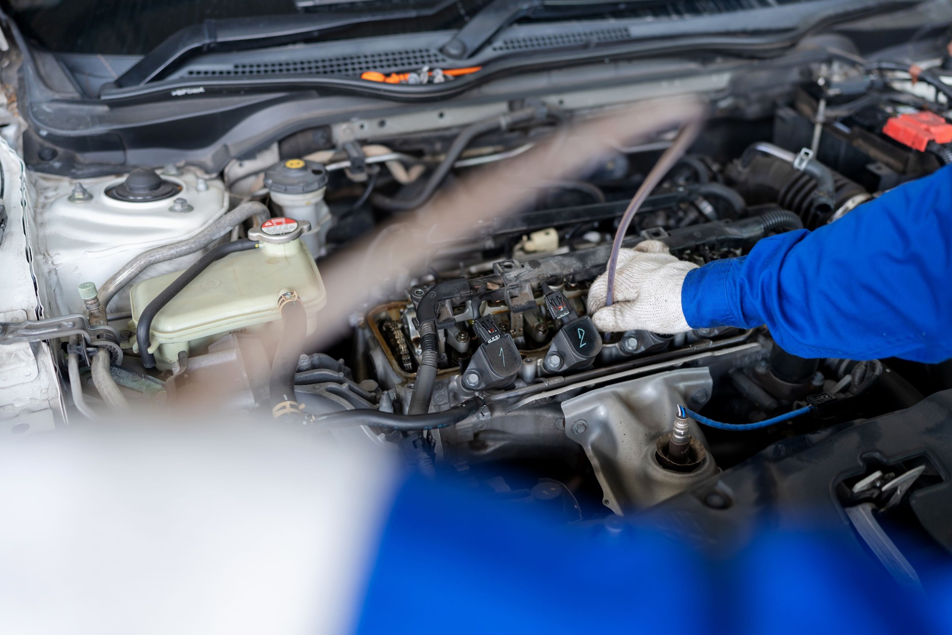 Check engine to increase engine efficiency. Professional car leader wearing mechanic uniform suit inspector the car engine and unscrew the nut to open the engine cover in the garage car repair shop to improve power efficiency.