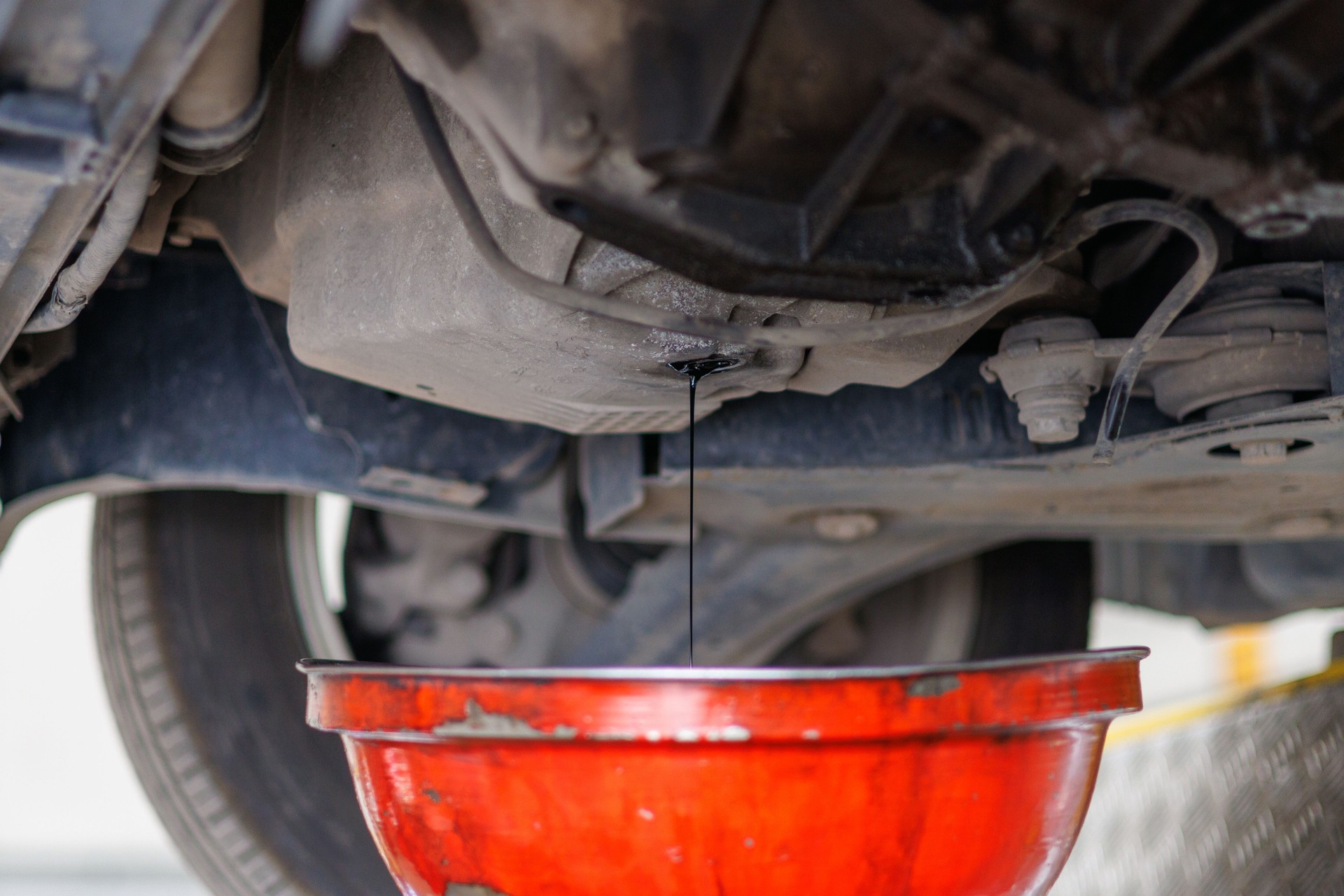 Mechanic changes engine oil in auto repair shop